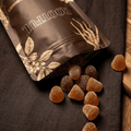 ROOTFUL Ashwagandha Gummies pouch overhead shot on grey linen with caramel-coloured gummies scattered around